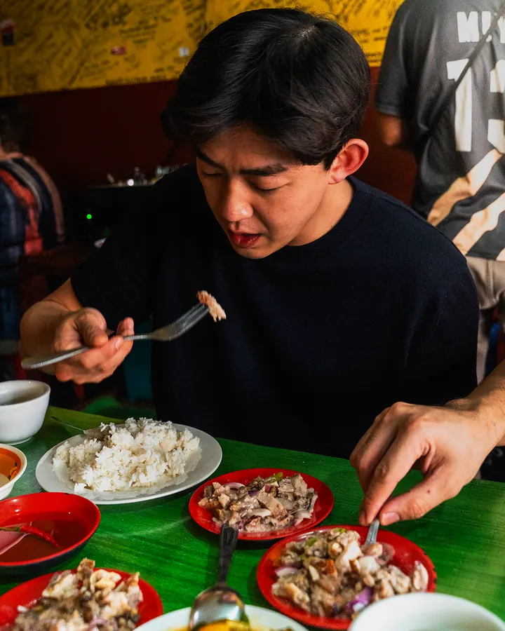 Guest eating at a table of shared dishes