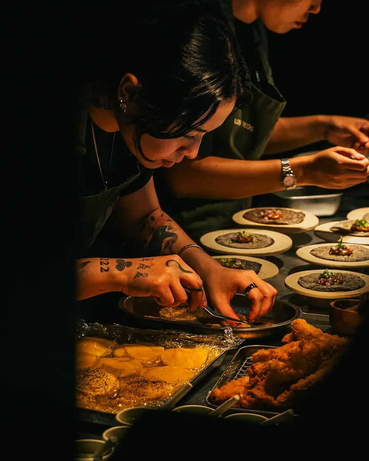 Cooks plating rows of dishes