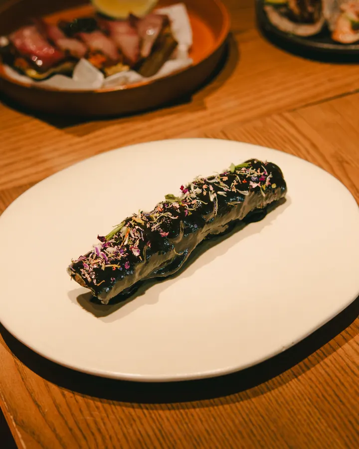 Plated roll topped with herbs on a wooden table