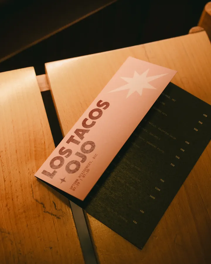 Los Tacos × OJO menu card on a table