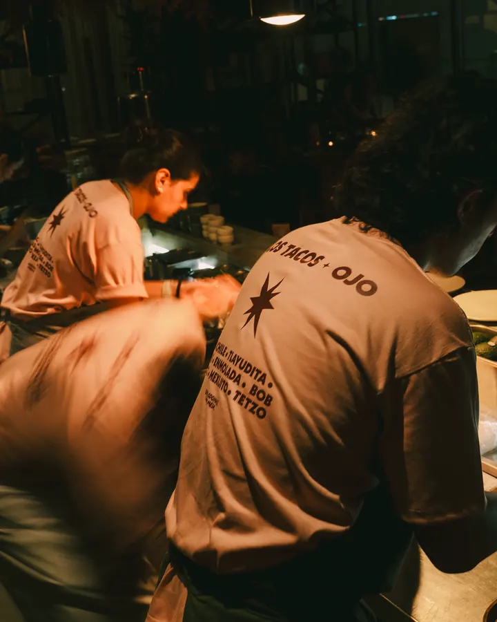 Cook in an OJO shirt leaning over the counter