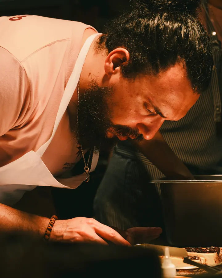 Chef leaning in close over a plate