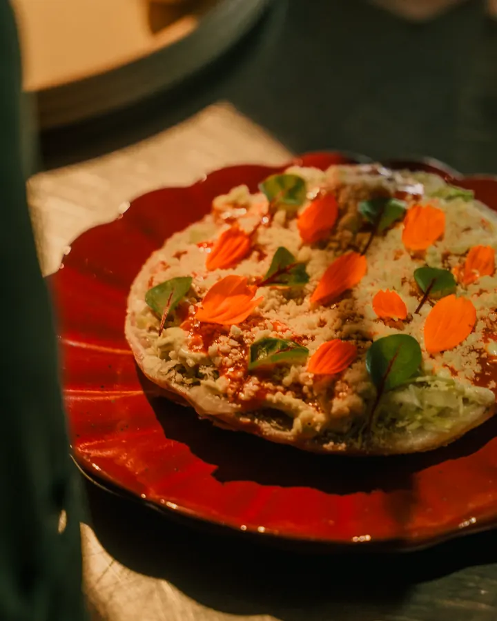 Tostada with diced vegetables on a red plate