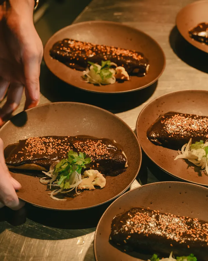 Row of plated fish with herbs at the pass
