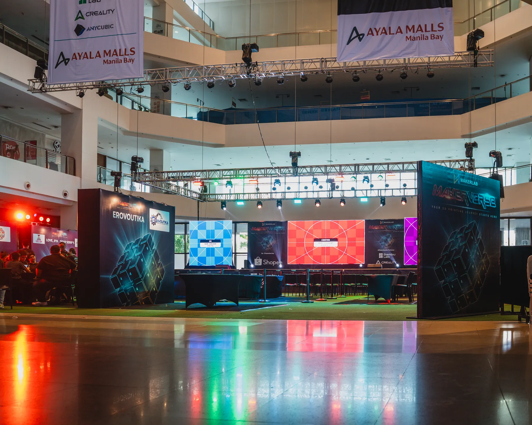 Event stage lit by colourful screens in a mall atrium