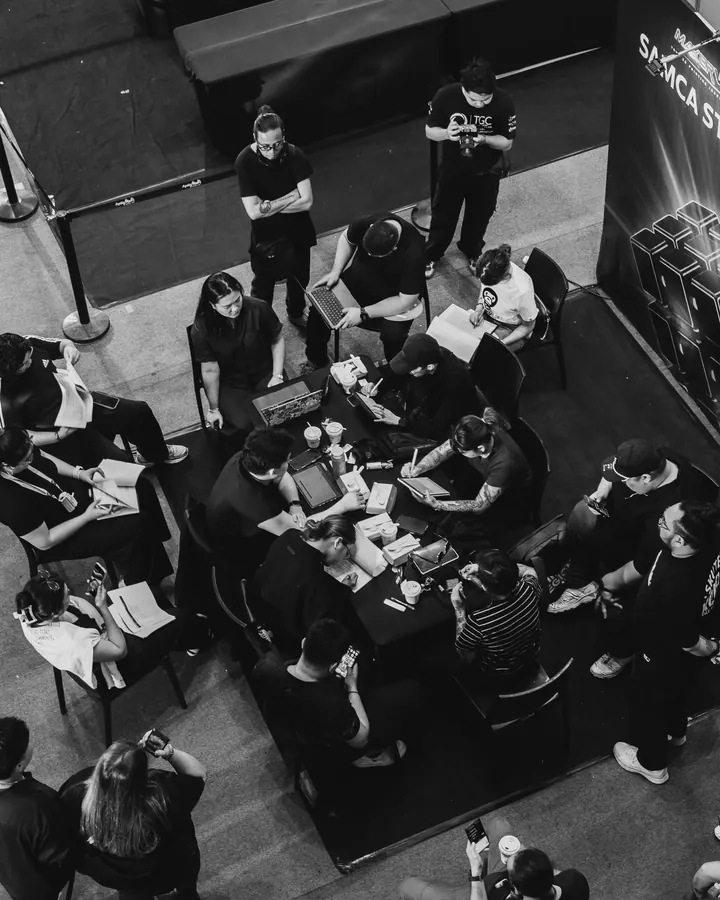 Overhead view of people working at tables, in black and white