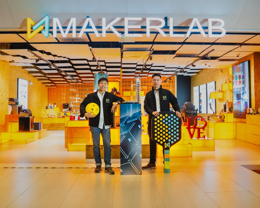 Two people posing in front of the Makerlab store
