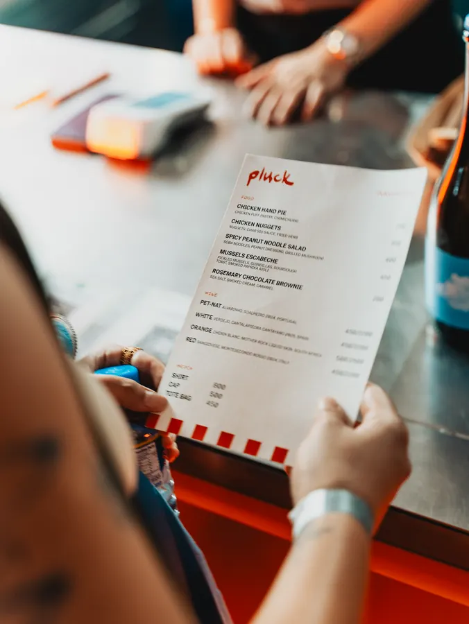 Hand holding the Pluck menu