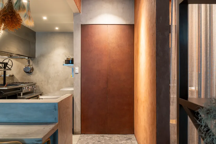 Copper-toned door and plaster wall