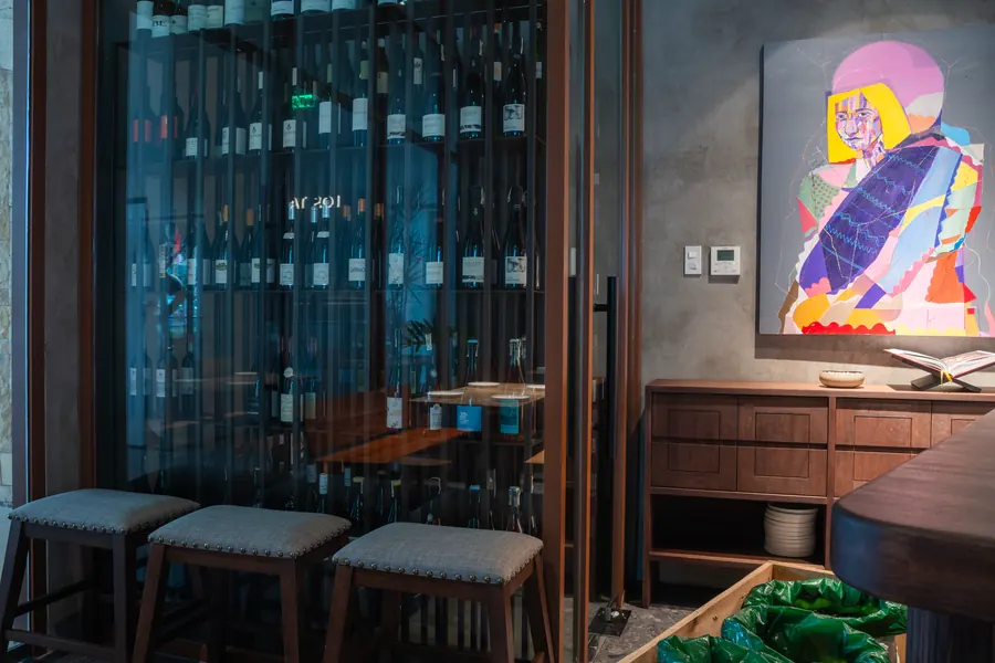 Wine wall beside a colourful portrait painting
