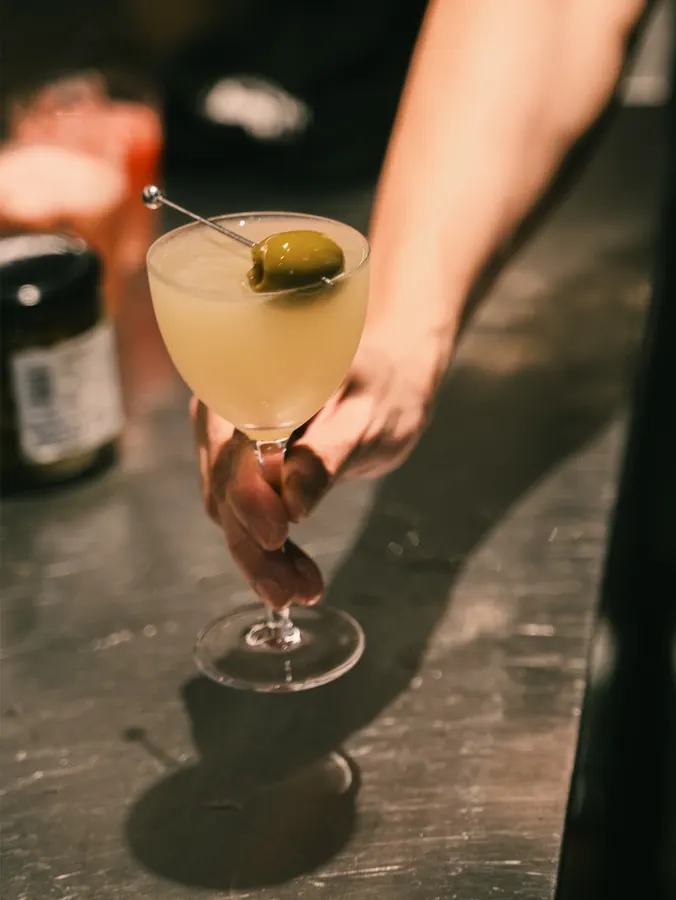 Martini with an olive on the bar