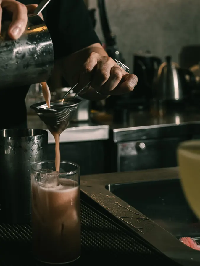 Straining a cocktail into a glass